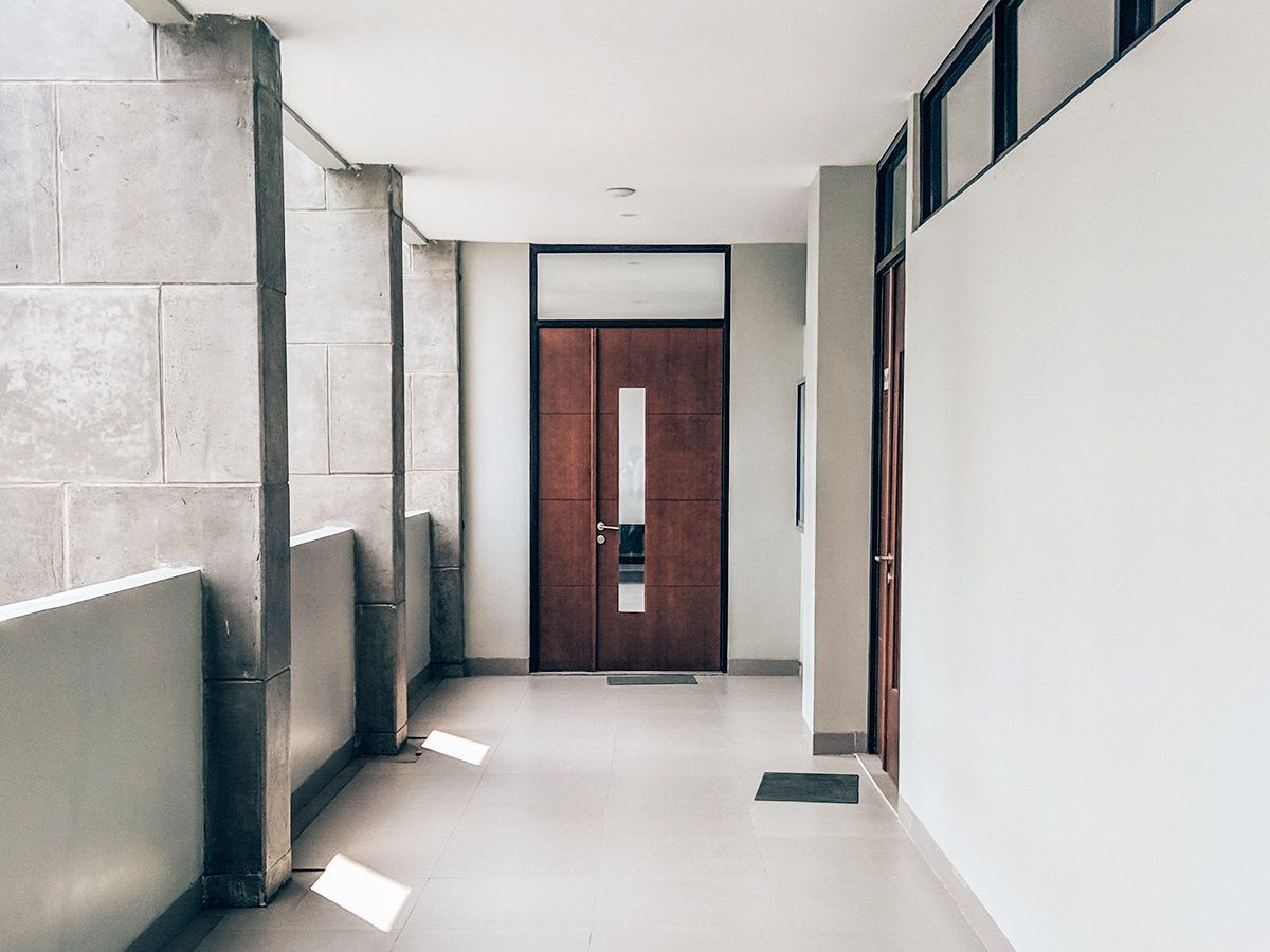 hallway in a school directly in front of large wooden door leading to classroom